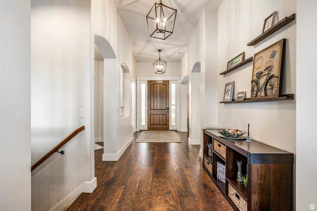 2311 South 1340 West St. George, UT 84770 - Photo 11 of 56 Foyer with arched walkways, dark wood finished floors, hanging lights, and a high ceiling