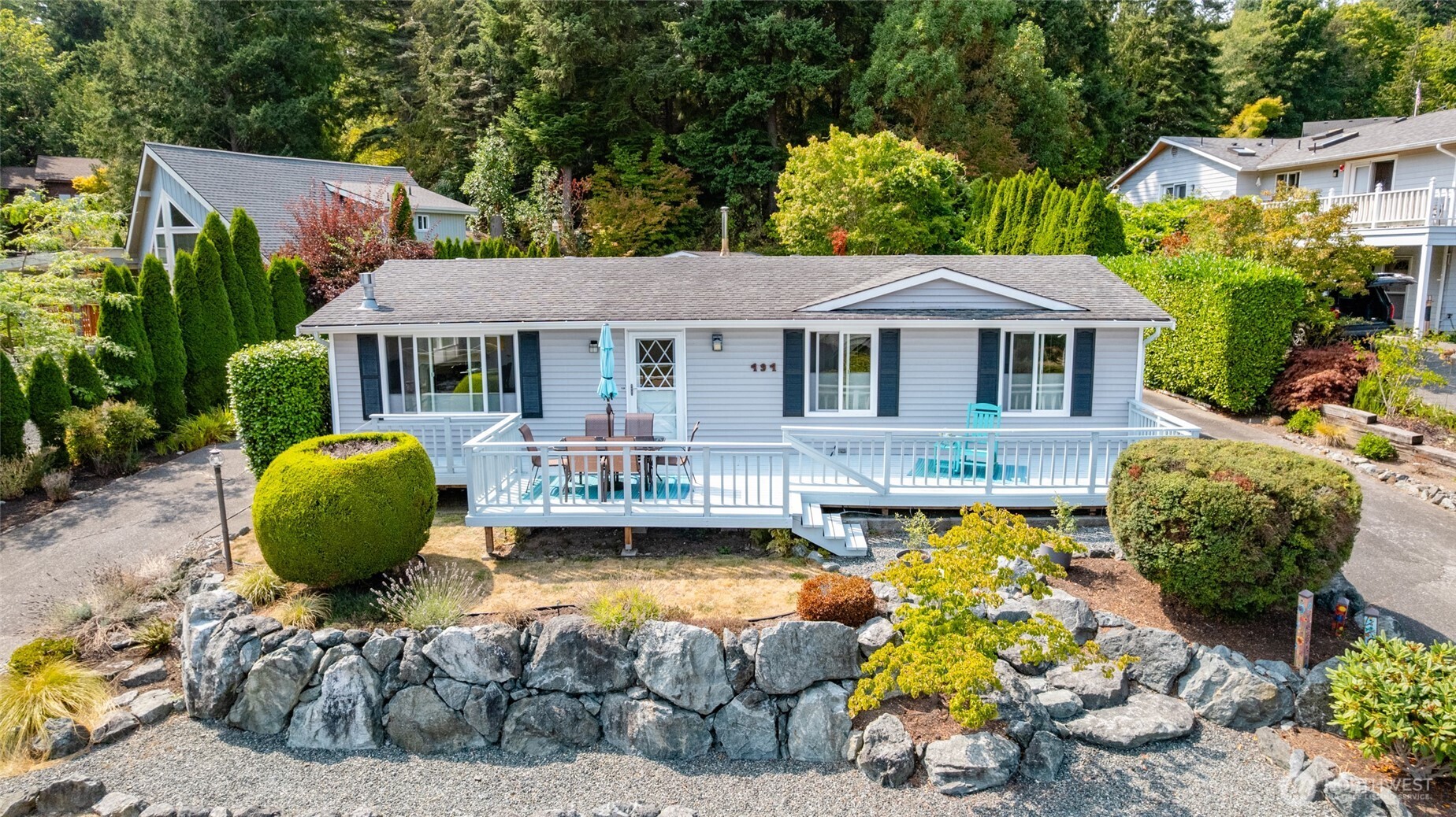 494 Colville Way La Conner, WA 98257 - Photo 1 of 39 a front view of a house with swimming pool lawn chairs and a fire pit