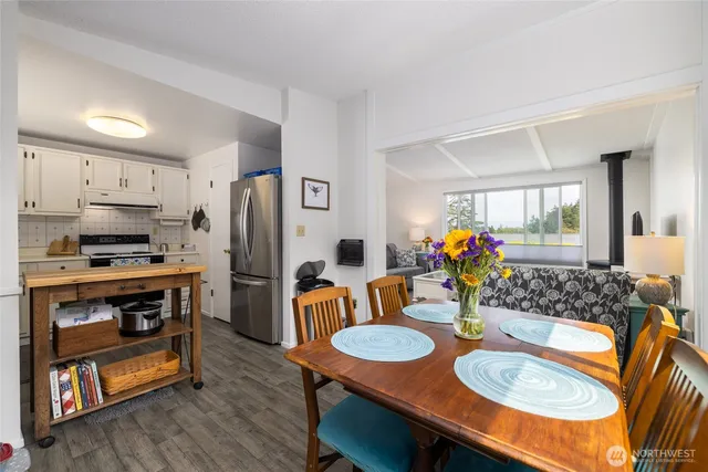 a open kitchen with stainless steel appliances granite countertop a stove a sink a dining table and chairs