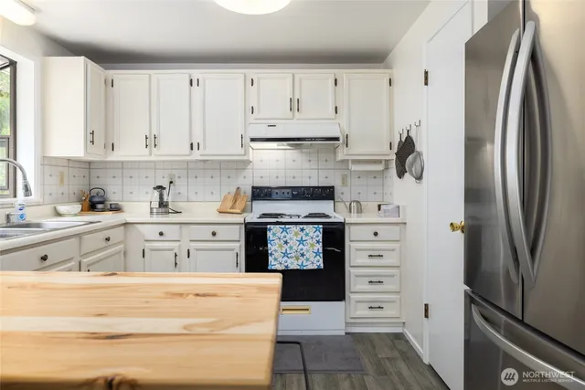 a kitchen with stainless steel appliances cabinets and a window
