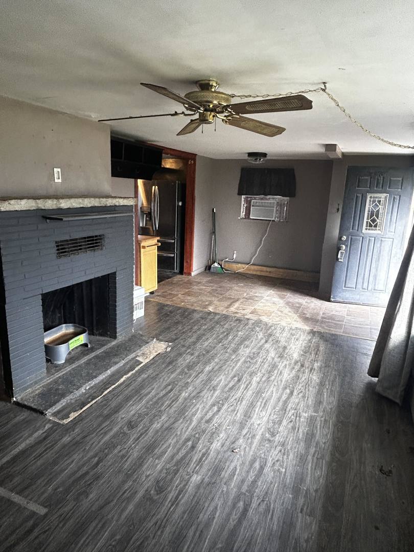 14328 Smith Road Lockport, IL 60441 - Photo 4 of 11 a view of an empty room with wooden floor fireplace and a window