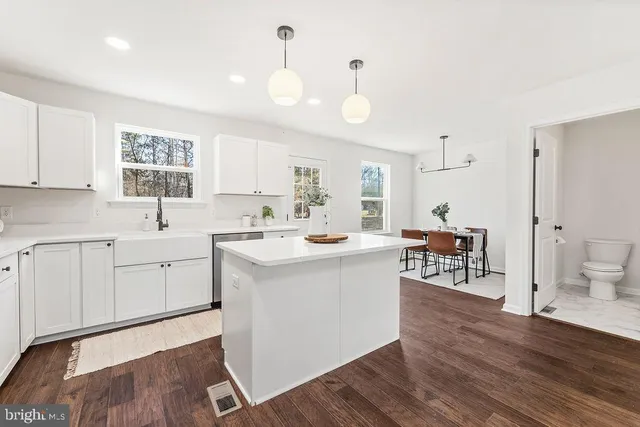a kitchen with a sink cabinets and wooden floor