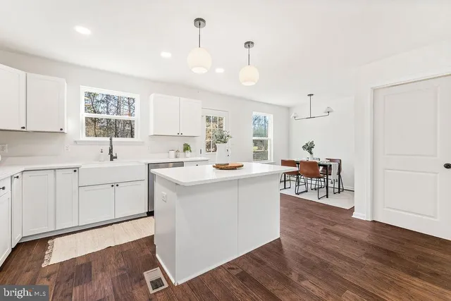 a kitchen with a sink cabinets and wooden floor