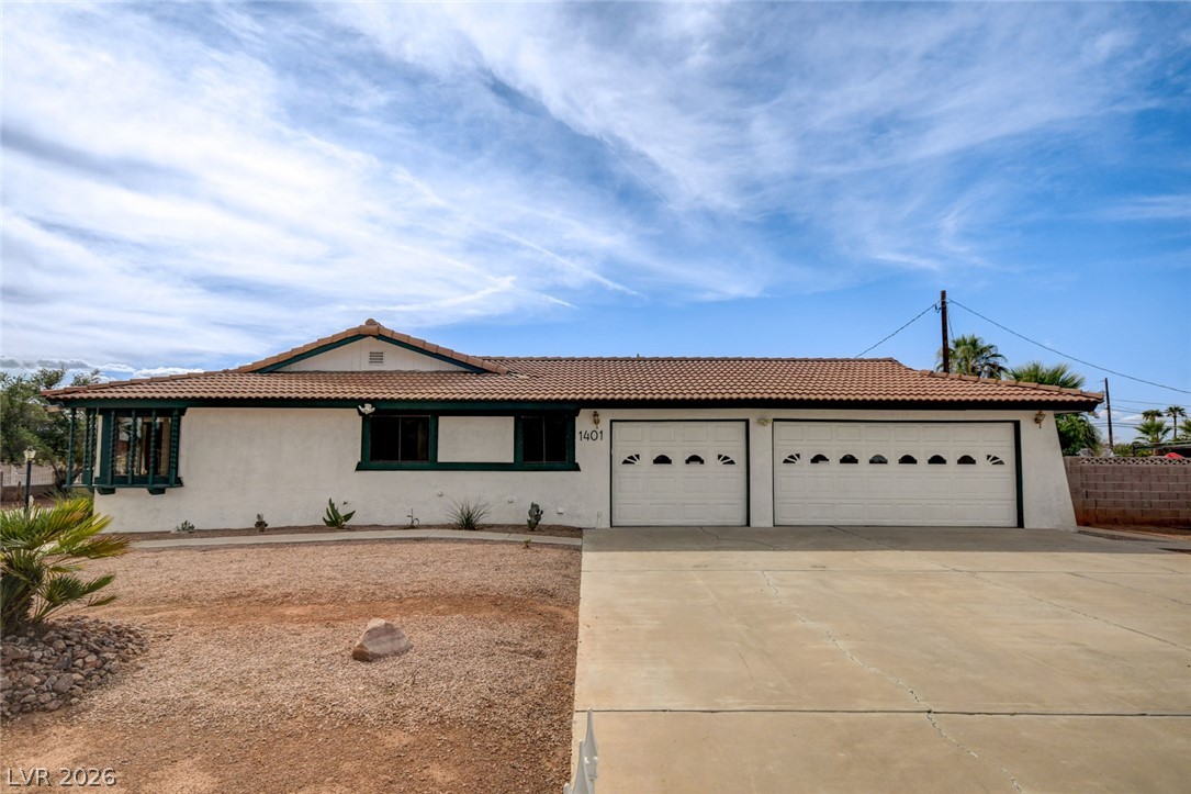 1401 Sharon Road Las Vegas, NV 89106 - Photo 9 of 73 Clay tile roofing and a wide concrete driveway frame this classic single-story desert home.