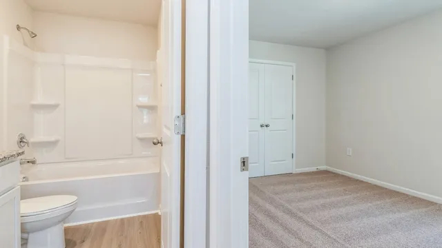 a bathroom with a granite countertop sink a toilet and shower