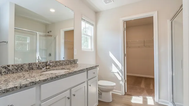 a bathroom with a granite countertop sink toilet and shower