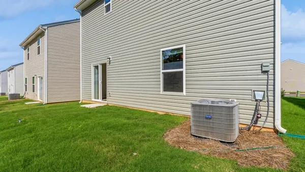 a view of a backyard with plants and a grill