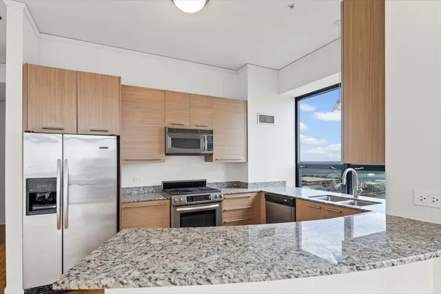 a kitchen with stainless steel appliances granite countertop a sink stove and refrigerator