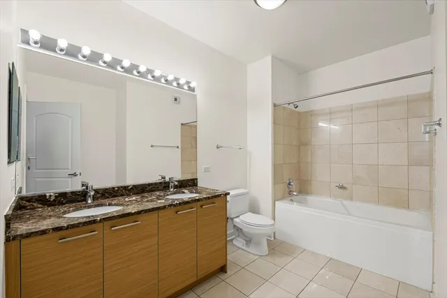 a bathroom with a granite countertop sink a toilet a mirror and shower