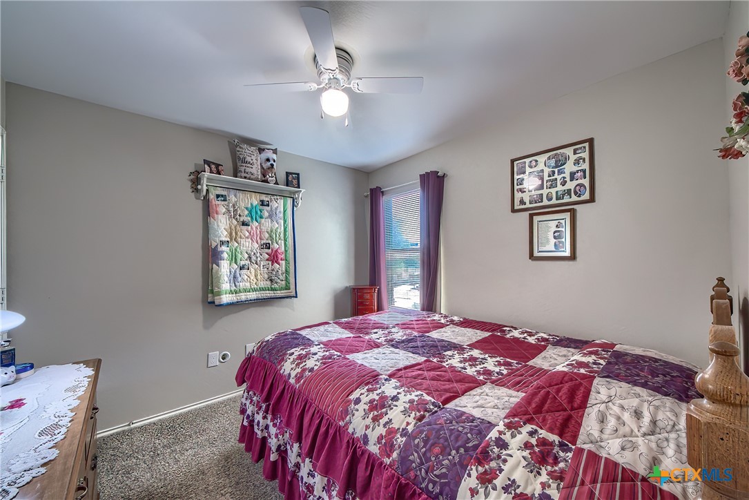 5709 Ping Way Schertz, TX 78108 - Photo 17 of 28 a bedroom with a large bed and a chandelier