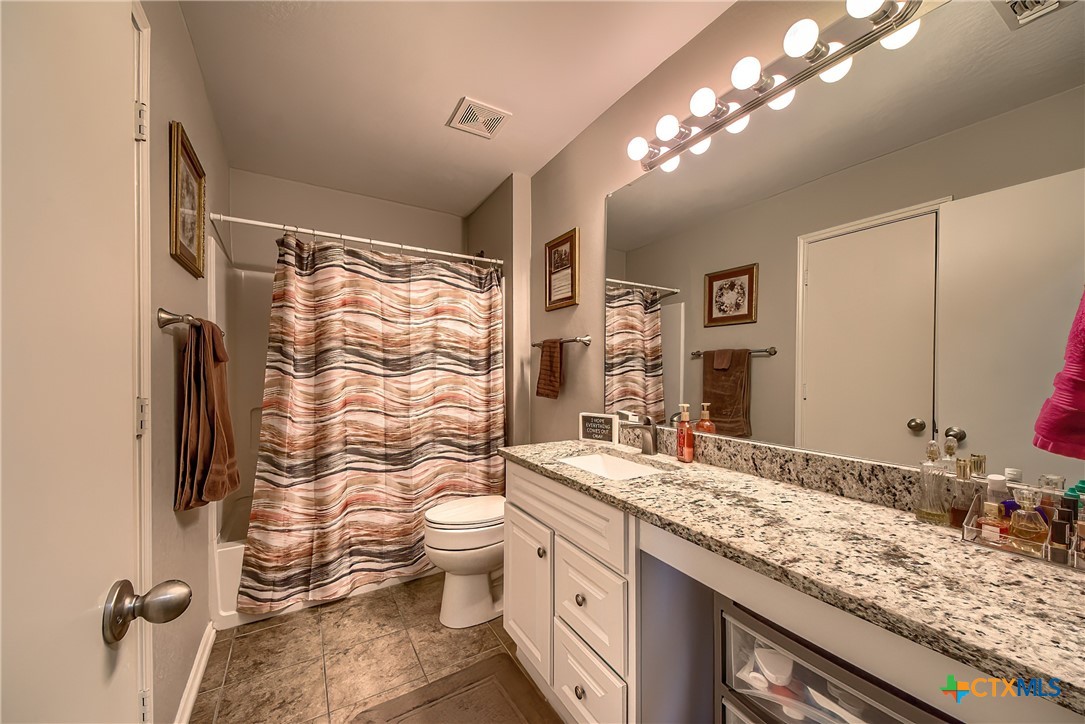 5709 Ping Way Schertz, TX 78108 - Photo 19 of 28 a bathroom with a granite countertop shower sink vanity and toilet