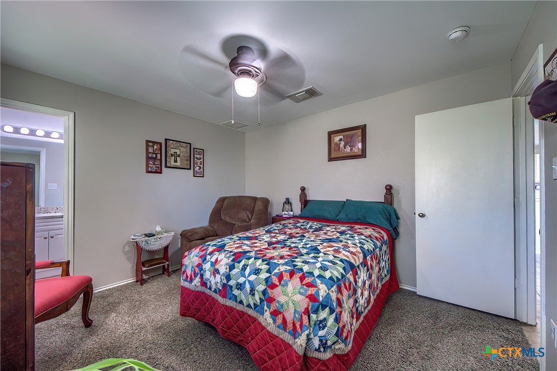 5709 Ping Way Schertz, TX 78108 - Photo 22 of 28 a bedroom with a bed and a chandelier