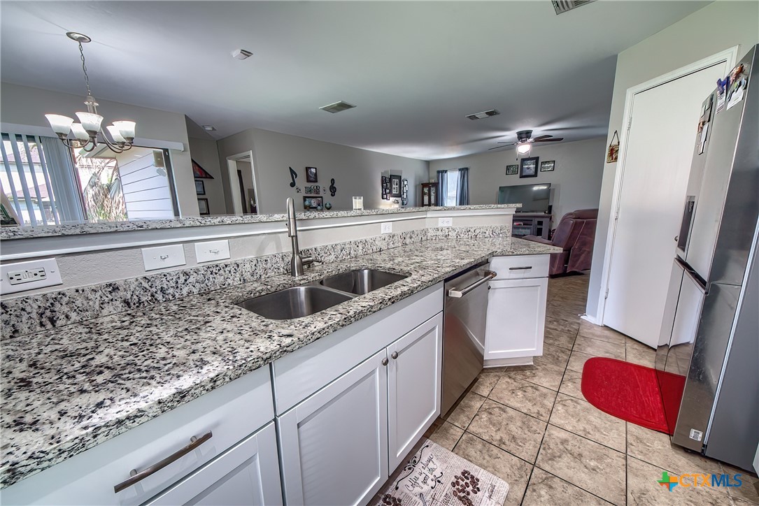 5709 Ping Way Schertz, TX 78108 - Photo 9 of 28 a kitchen with stainless steel appliances granite countertop a sink refrigerator and cabinets
