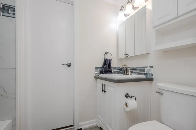 a bathroom with a sink a toilet and a mirror