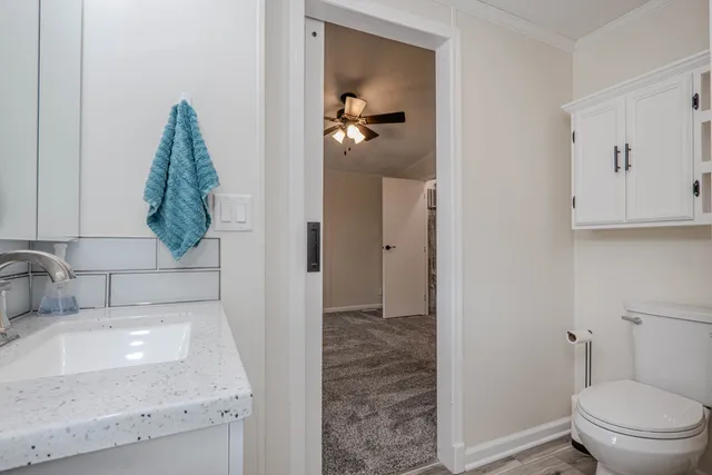 a bathroom with a granite countertop sink a toilet and a mirror