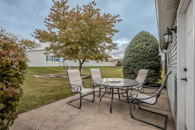 a backyard of a house with table and chairs