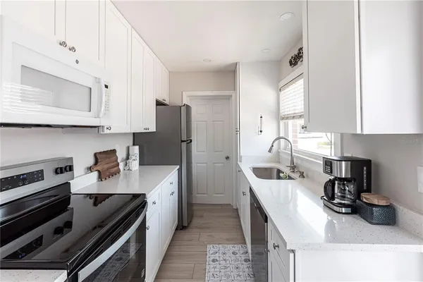 a kitchen with stainless steel appliances a sink stove refrigerator and cabinets