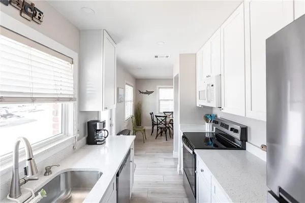 a kitchen with stainless steel appliances granite countertop a sink stove and cabinets