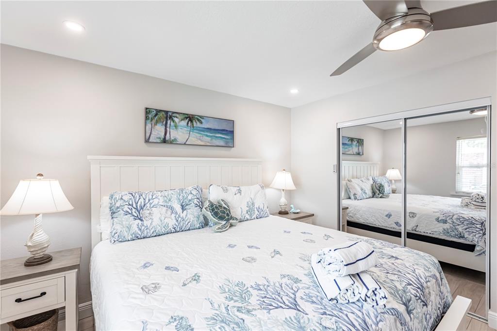 6020 Midnight Pass Road, Unit 56 Sarasota, FL 34242 - Photo 20 of 29 a bedroom with a large bed and a lamp