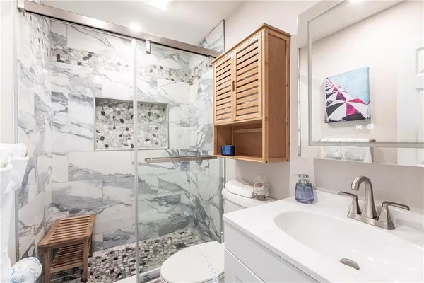 a bathroom with a sink toilet and shower