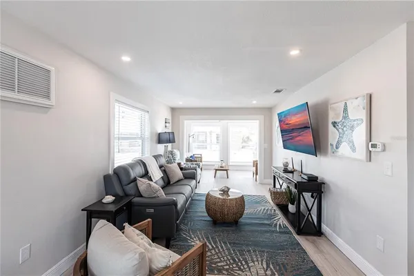 a living room with furniture a flat screen tv and a window