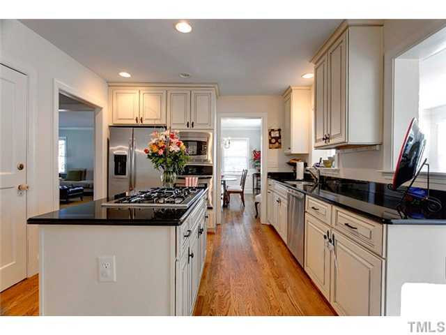 1803 Arlington Street Raleigh, NC 27608 - Photo 6 of 12 a kitchen with kitchen island granite countertop a sink cabinets and stainless steel appliances