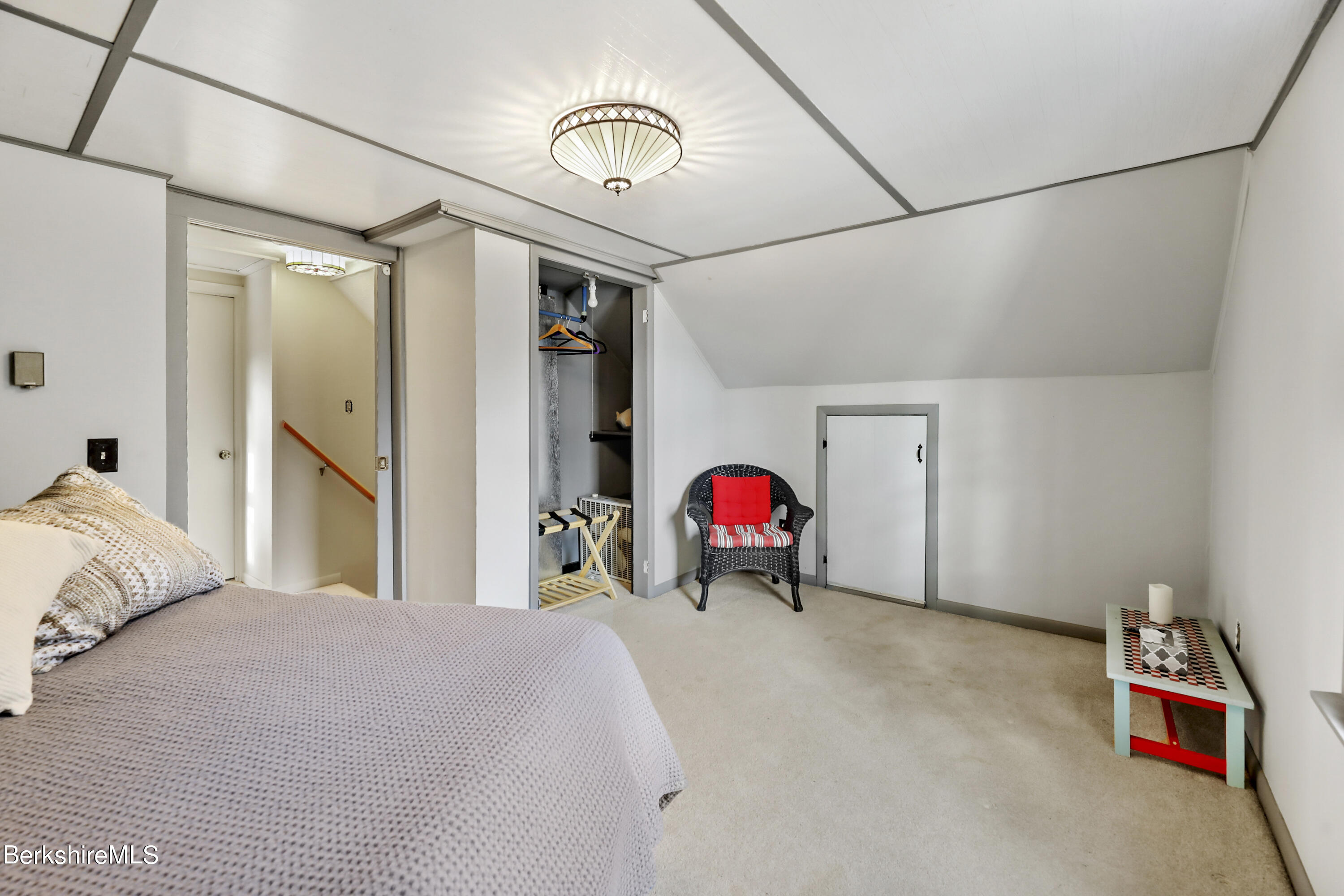 1831 North Main Road Otis, MA 01253 - Photo 52 of 69 a bedroom with a bed and a chandelier