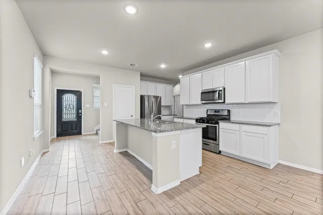a kitchen with white cabinets stainless steel appliances and sink