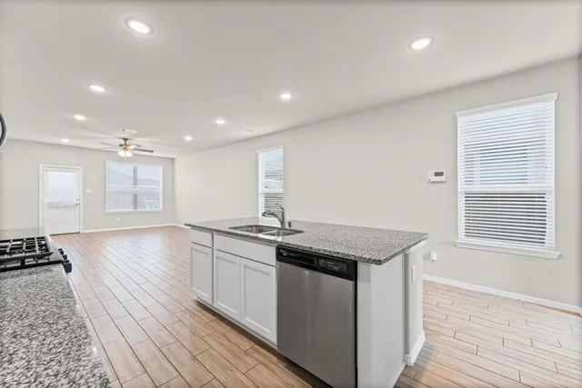 a kitchen with stainless steel appliances granite countertop a sink stove and cabinets