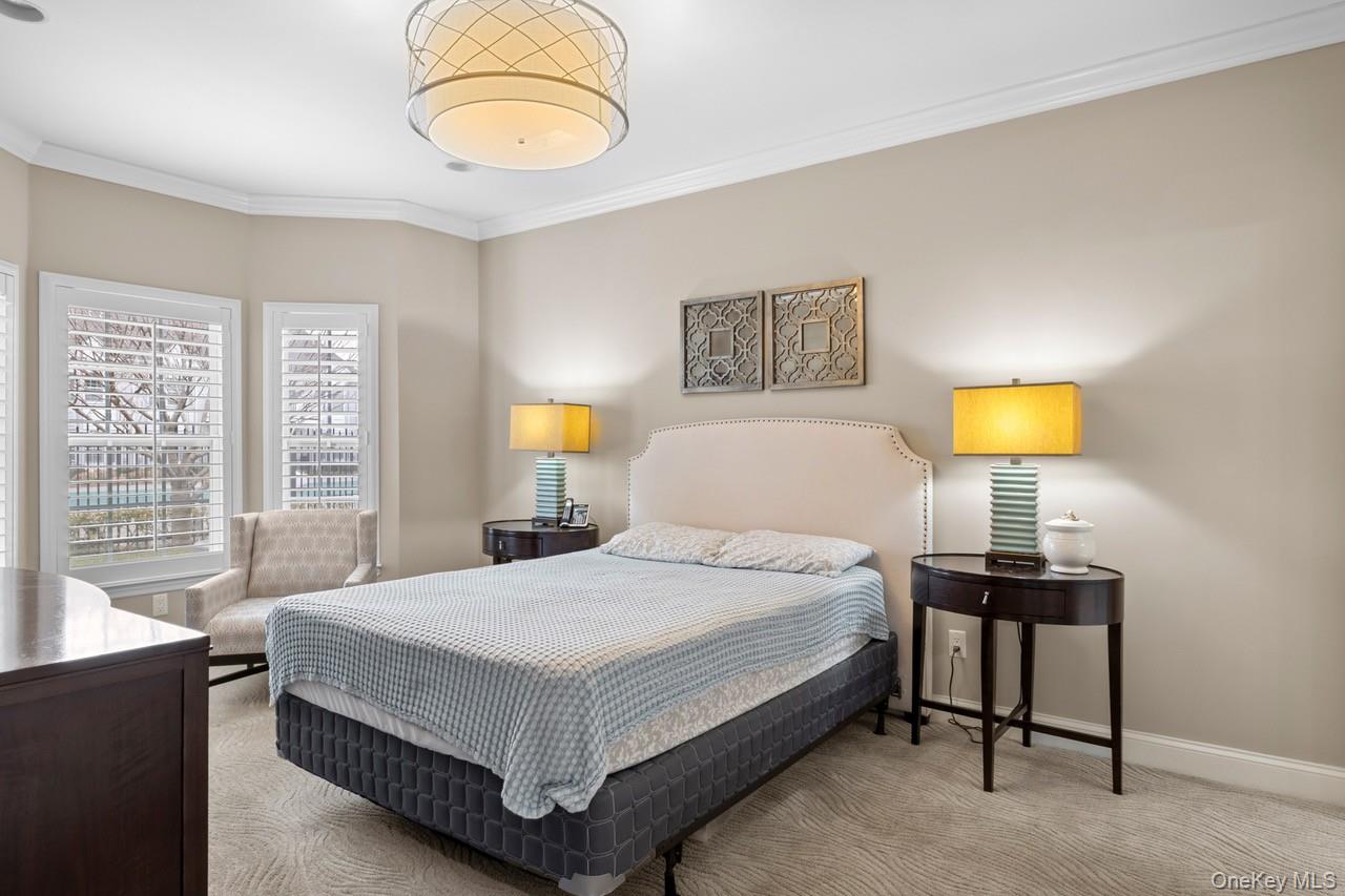 56 Spring Drive Seaford, NY 11783 - Photo 13 of 42 a bedroom with a bed and a chandelier