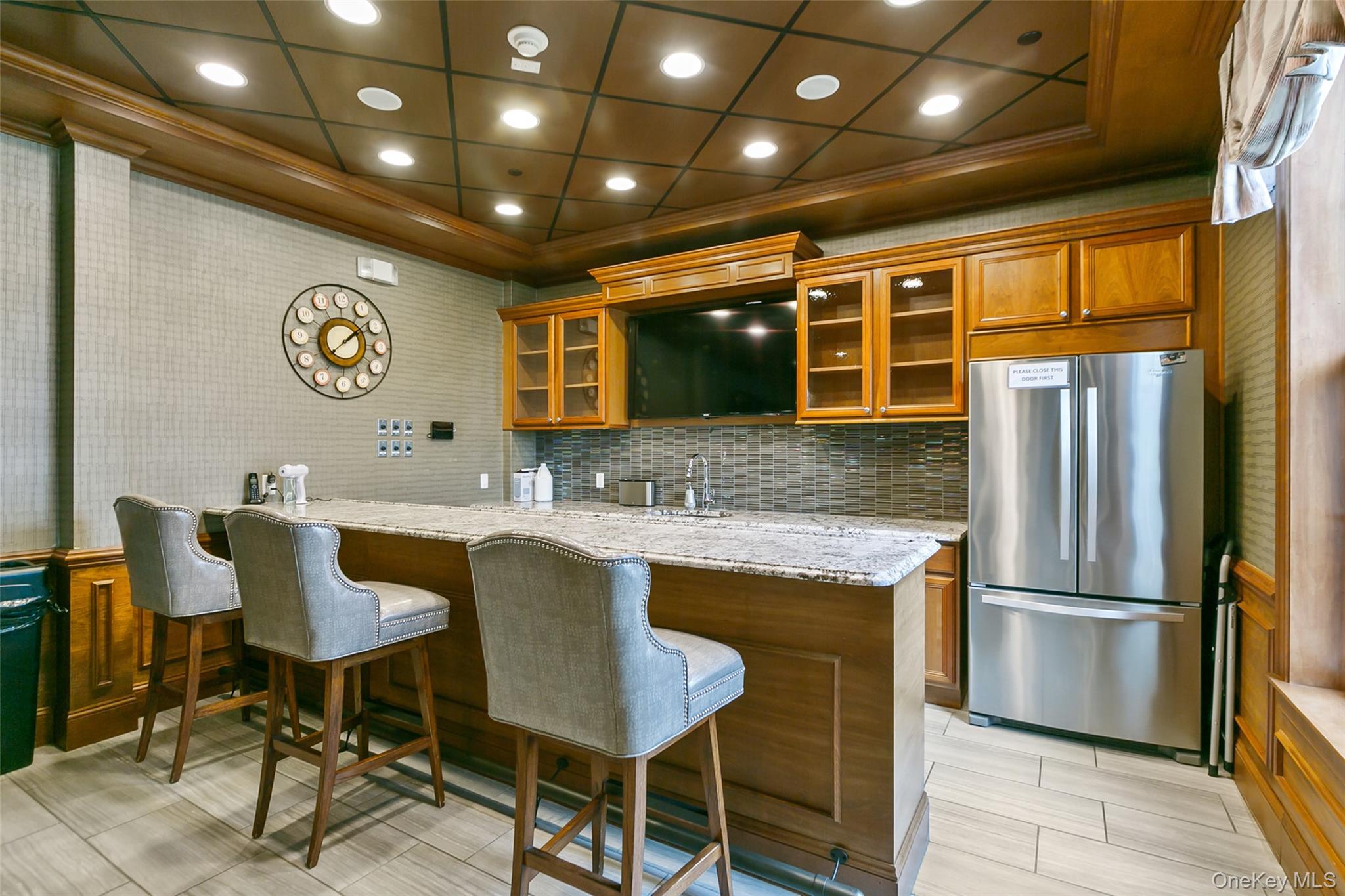 56 Spring Drive Seaford, NY 11783 - Photo 30 of 42 a kitchen with stainless steel appliances granite countertop a table chairs and a refrigerator