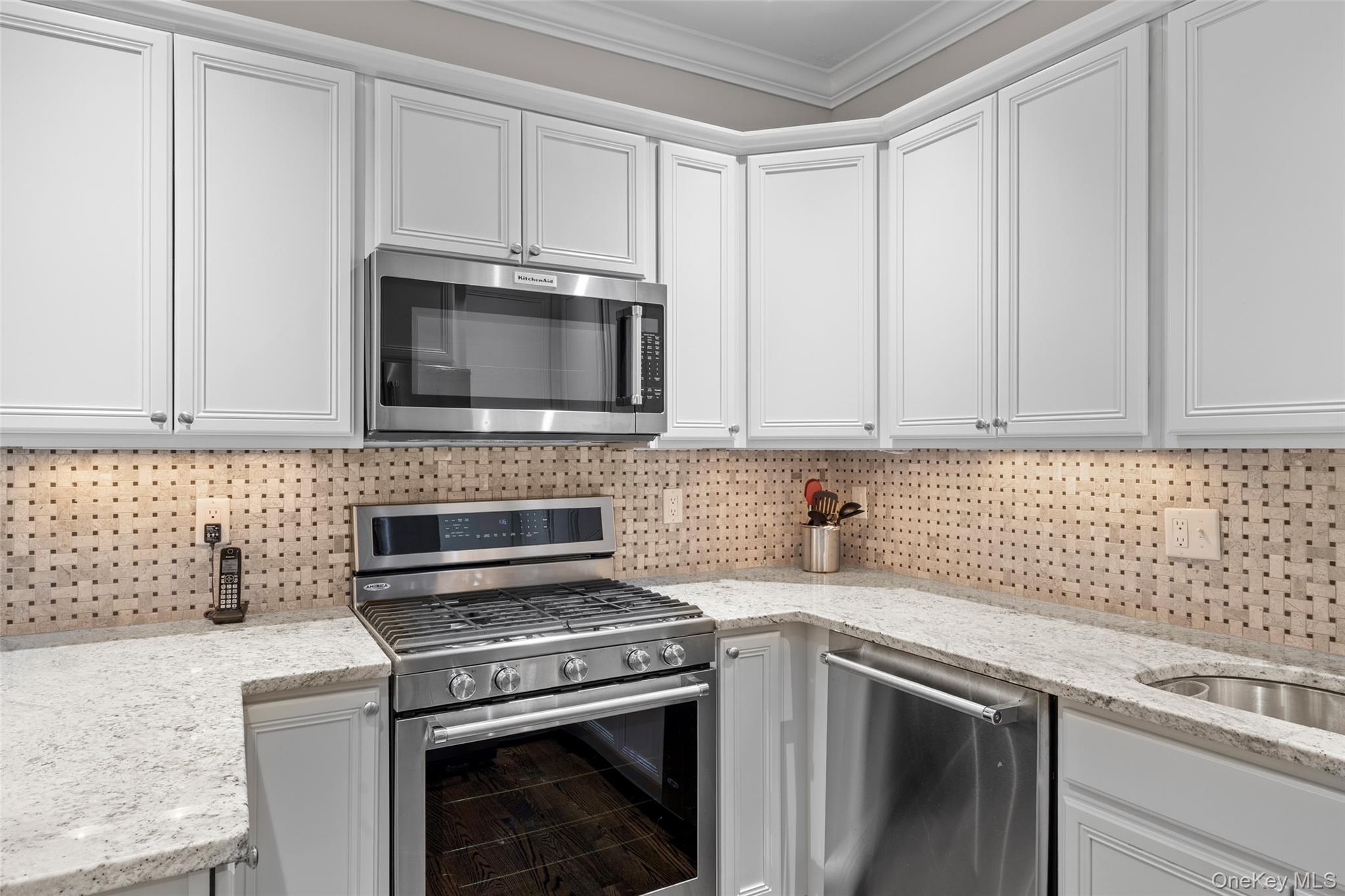 56 Spring Drive Seaford, NY 11783 - Photo 10 of 42 a kitchen with granite countertop white cabinets stainless steel appliances and a sink