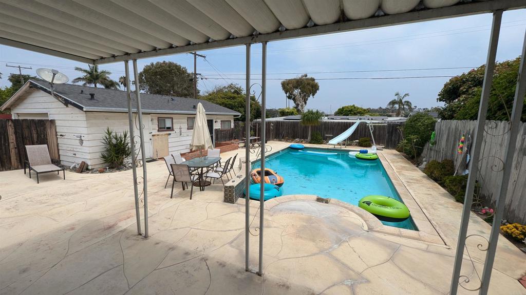 5158 Los Robles Drive Carlsbad, CA 92008 - Photo 20 of 31 a view of a patio with a dining table and chairs with wooden fence