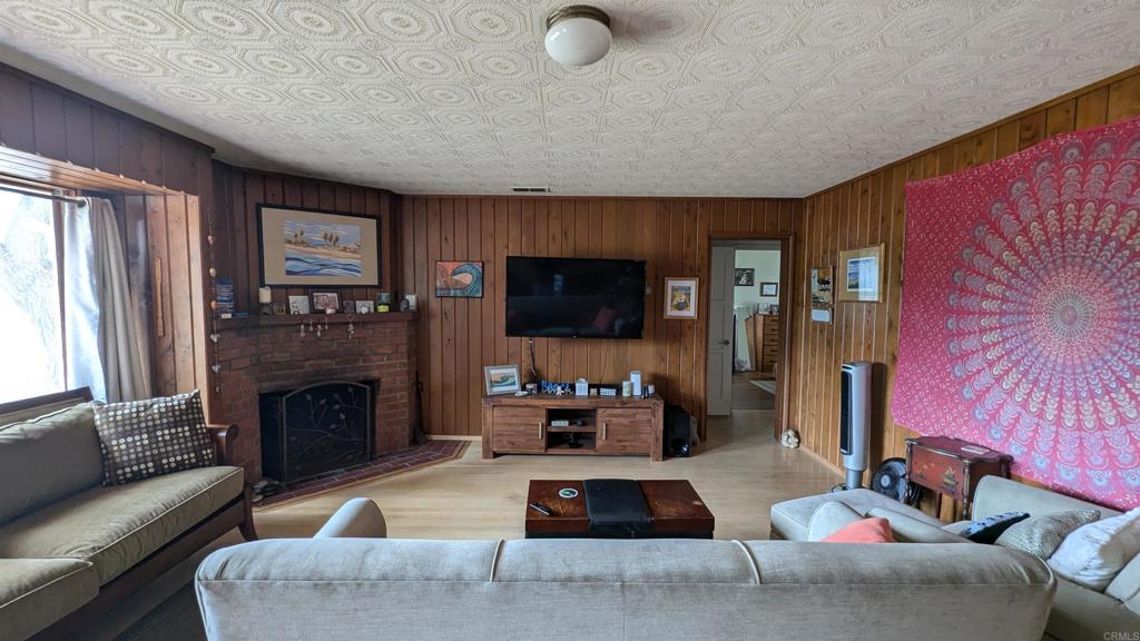 5158 Los Robles Drive Carlsbad, CA 92008 - Photo 4 of 31 a living room with furniture a flat screen tv and a fireplace
