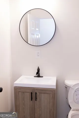 a bathroom with a sink a toilet and mirror