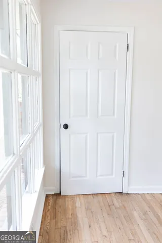 a view of a hallway with wooden floor and entryway