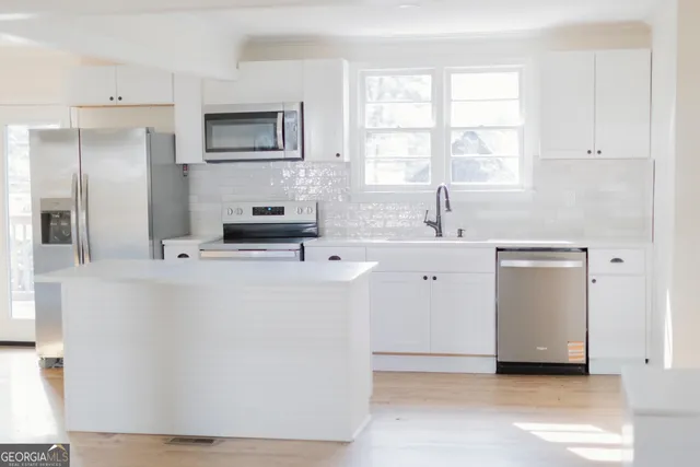 a kitchen with a sink appliances and cabinets