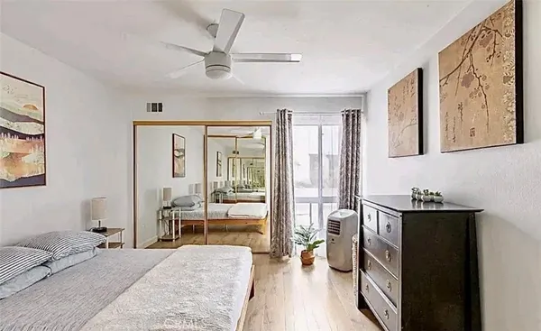 a bedroom with a bed and wooden floor