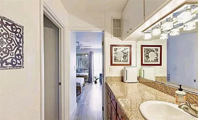 a en suite bathroom with a granite countertop double vanity sink and a mirror