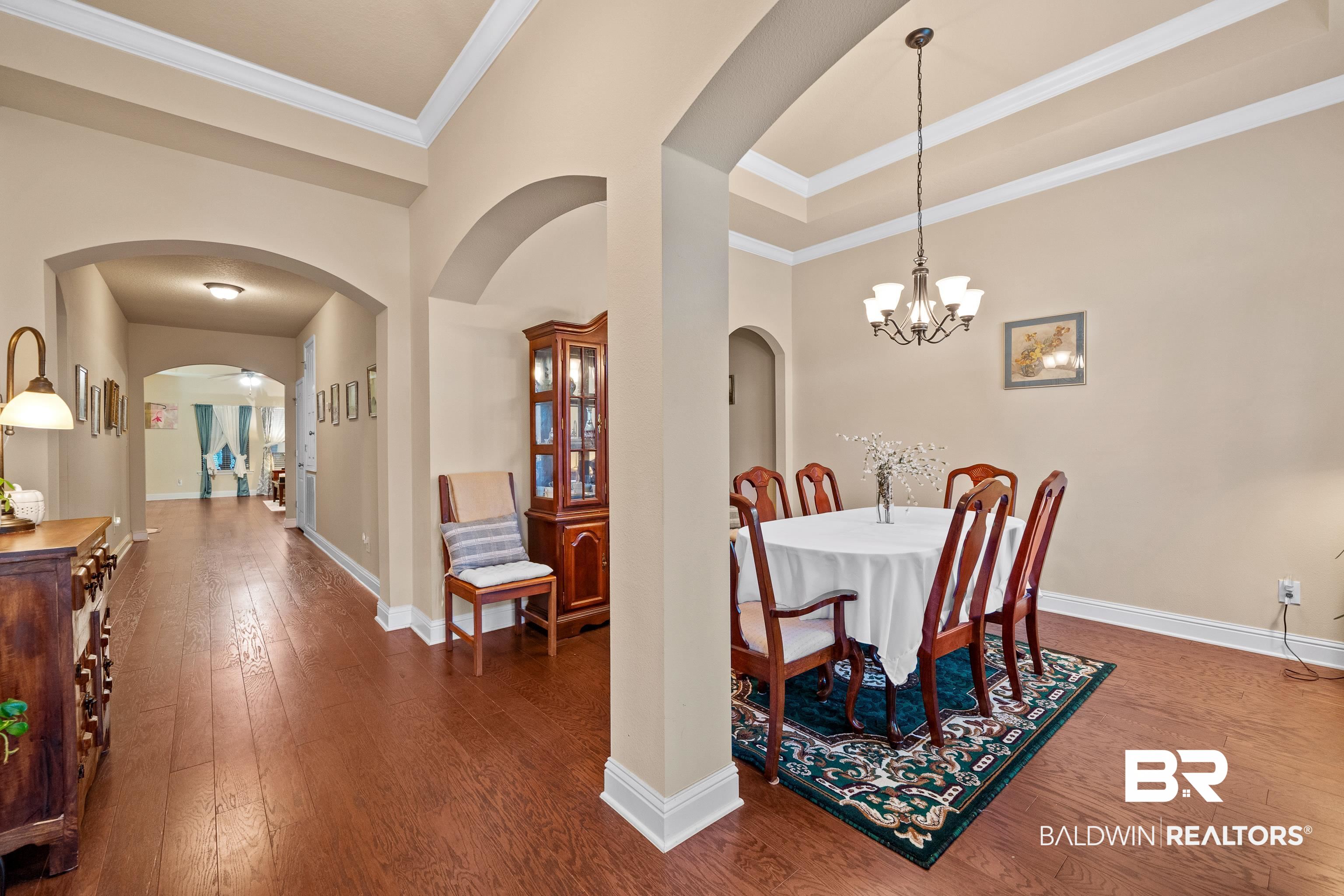 9115 Krystal Ridge Court Daphne, AL 36526 - Photo 5 of 39 Dining space with a chandelier, crown molding, and dark wood-type flooring