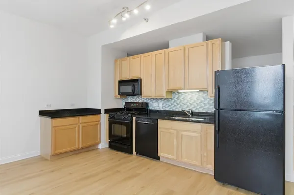 a kitchen with stainless steel appliances granite countertop a refrigerator sink and stove