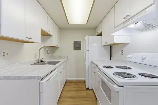 a kitchen with a sink cabinets and wooden floor