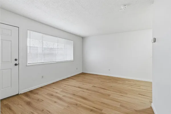 a room with wooden floor and cabinets