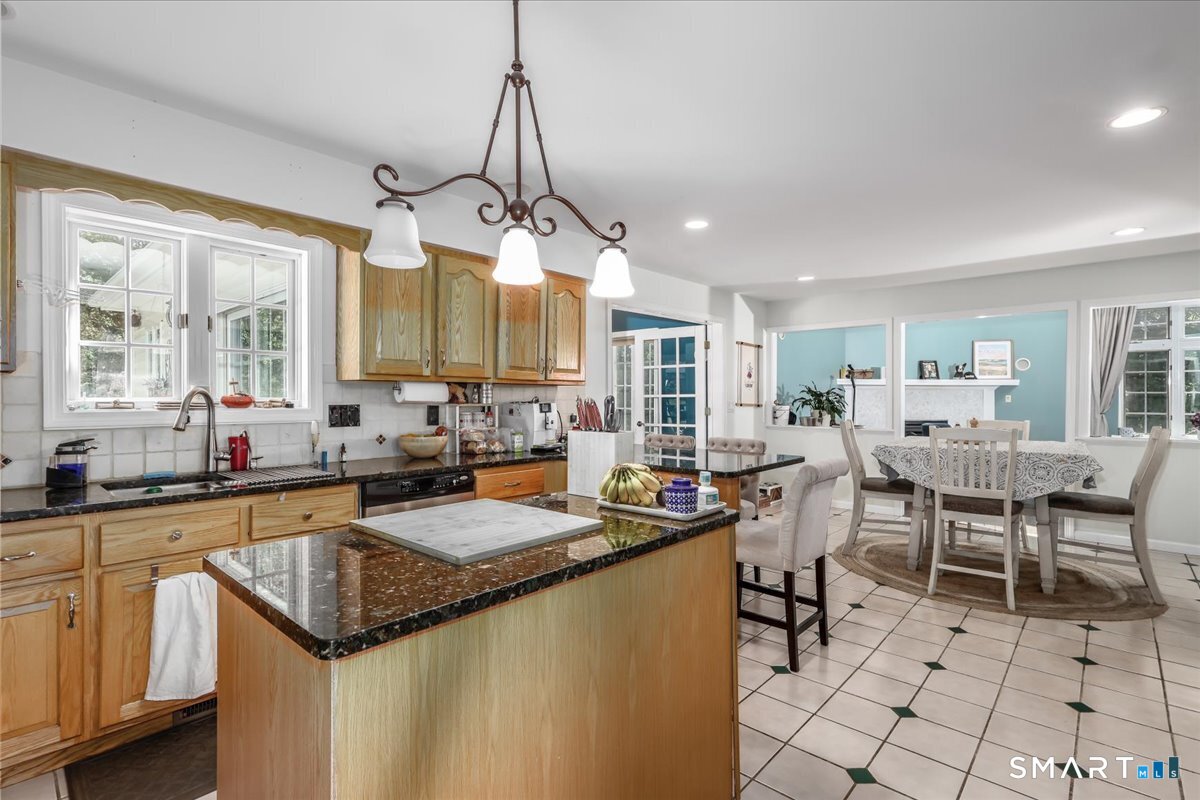 55 A Flax Hill Road Brookfield, CT 06804 - Photo 12 of 40 a open kitchen with stainless steel appliances granite countertop a sink a stove a dining table and chairs with white cabinets