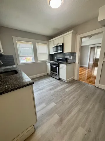 a kitchen with stainless steel appliances granite countertop a stove and a sink