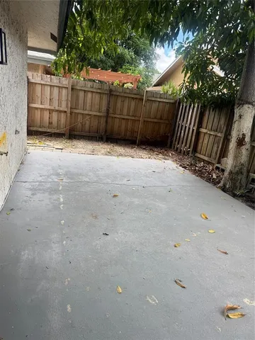 a view of backyard and wooden fence