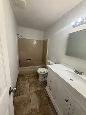 a bathroom with a granite countertop sink a toilet a mirror and shower