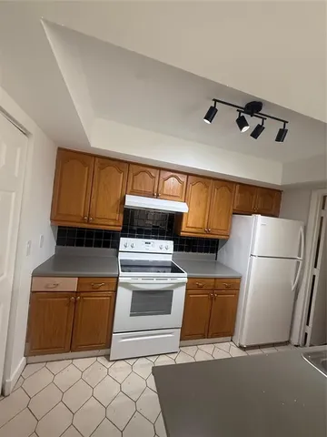 a kitchen with granite countertop a refrigerator and a stove