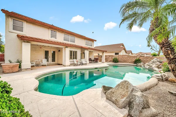 a front view of a house with swimming pool having outdoor seating