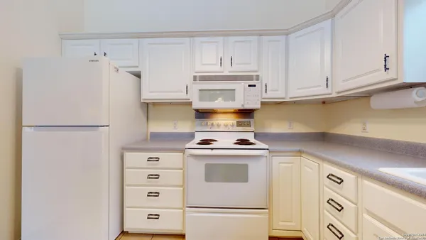 a kitchen with cabinets appliances a sink and a counter